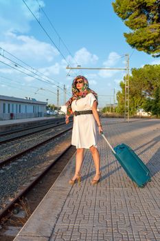 Girl with a suitcase at the train station. High quality photo