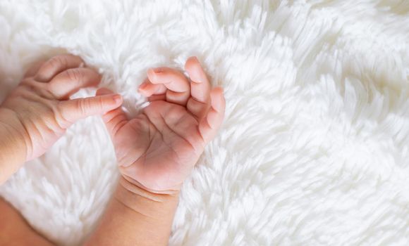 hands of a newborn toddler on a white background. selective focus. people.