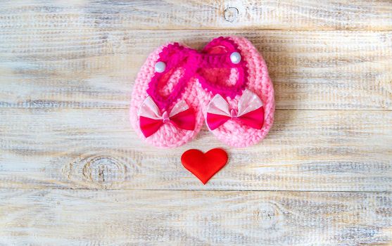 Baby booties and heart on a light background. Selective focus. nature.