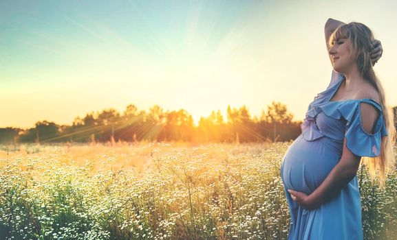 pregnant woman with camomiles in hands. Selective focus. nature.