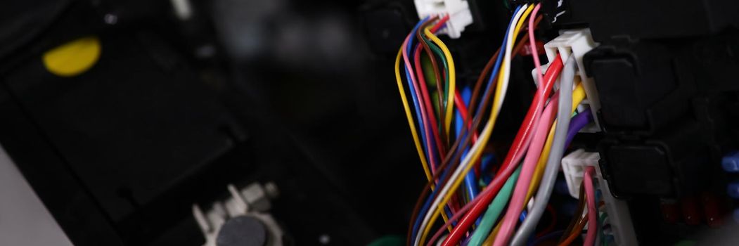 Close-up of large wide cable with multicolored wires and connectors in car. Electric connector plug of car engine. Maintenance for automobile fix concept