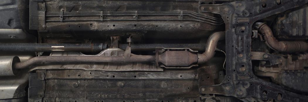 Close-up of car lifted in maintenance service to check availability undercarriage of automobile. Bottom view of pickup machine. Pit stop, service concept