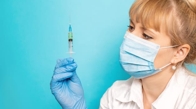 Doctor with a syringe in his hands. Selective focus.