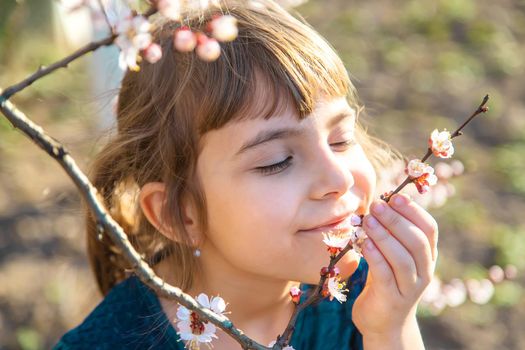 A child in the garden of flowering trees. Selective focus. Nature.