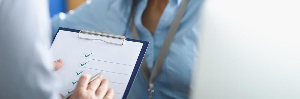 Portrait of brunette woman answer to survey questions to coworker standing with paper. Potential new worker being interviewed. Job, consultation concept