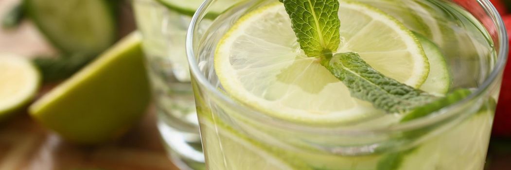 Close-up of fresh homemade lime with cucumber cocktail served with mint twig on top. Refreshing drink for hot summer days. Party, recipe, beverage concept