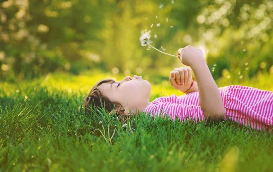 Child girl with dandelions in the park. Selective focus.