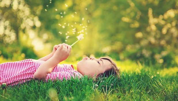 Child girl with dandelions in the park. Selective focus.