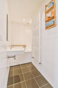 Sinks with mirrors and clean bathtub located near shower box with glass door in modern bathroom with white tiled walls