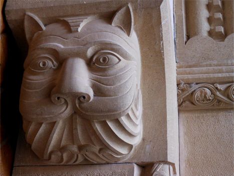 Face of a cat-like animal carved into a stone column