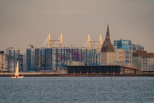 The residential complex under construction on the embankment of the Neva River on Vasilievsky island in sunset, bulk island, construction cranes. High quality photo