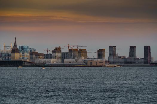 The residential complex under construction on the embankment of the Neva River on Vasilievsky island in sunset, bulk island, construction cranes. High quality photo