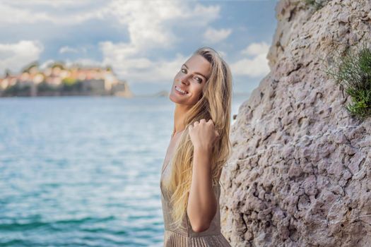 Woman tourist on background of beautiful view of the island of St. Stephen, Sveti Stefan on the Budva Riviera, Budva, Montenegro. Travel to Montenegro concept.