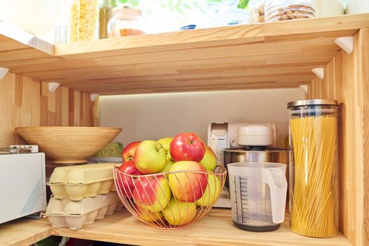 Storage of food in the kitchen in the pantry. Cereals, pasta, eggs, apples, kitchen utensils. Cooking at home, household