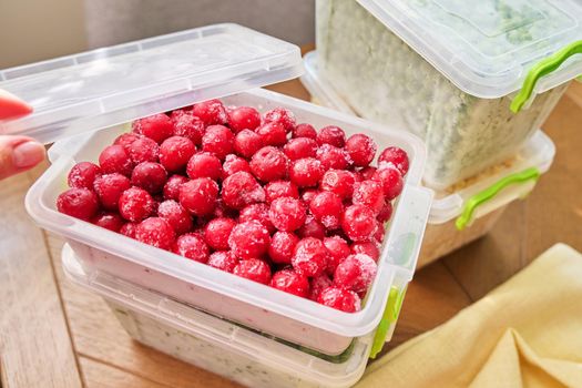 Frozen vegetables and fruits, close-up frozen in the freezer cherry in plastic containers. Seasonal vegetables, food preparations for the winter