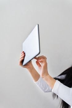 Business lady holds a tablet in her hands and works outside the office, remote robot. Modern technologies and business