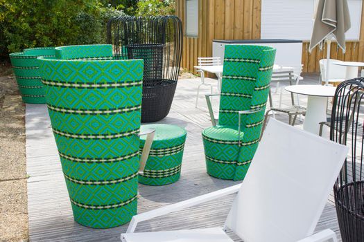 Restaurant with green wicker chairs, tables and different chairs