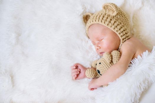 A newborn baby sleeps with a teddy bear. Selective focus. people.