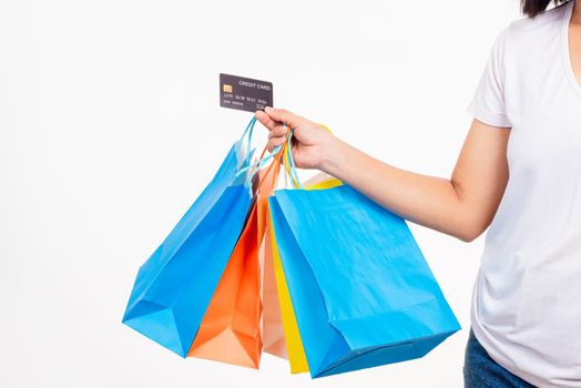 Happy woman hand holding shopping bags multicolor and credit card for shopping online, young female hold many packets within arms isolated on white background, Black Friday sale concept