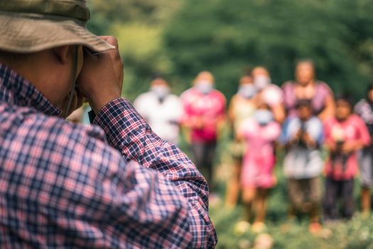 Latin American photographer taking a picture of a group of unrecognizable peasants in Masaya Nicaragua