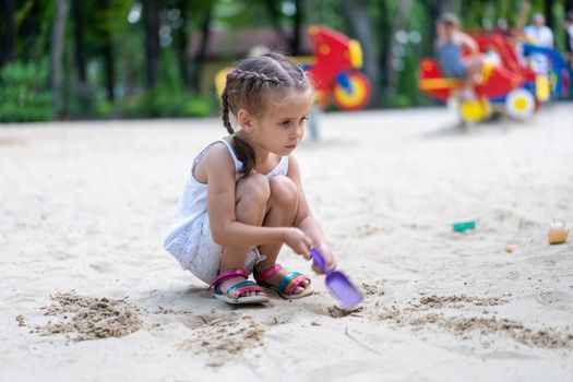 Little Girl Playing Sandbox Playground Digging Sand Shovel Building Sand Figure Summer Day. Caucasian Female Child 5 years Have Fun Outdoor