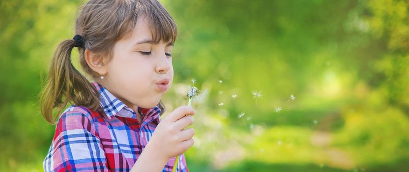 Child girl with dandelions in the park. Selective focus.