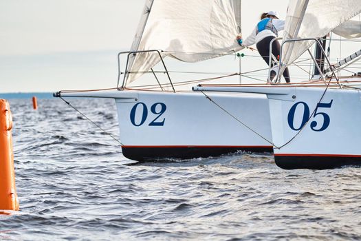 Bowsprits of sailing yachts in sailing regatta at sunset, still water, the clear sky, hot racing. High quality photo
