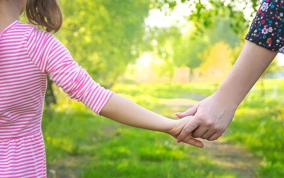 A child with his mother goes by the hand. Selective focus. nature.