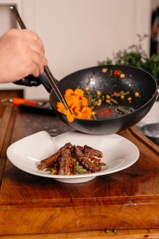 Beef Meal Decorated with Carrot. Plating. Fried Vegetables. Food on a White Plate. Food Art Cooking.