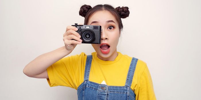 Asian woman using camera while smiling