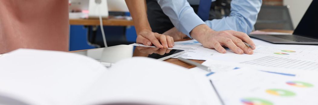 Business man and woman studying documents at table in office closeup. Business strategy concept