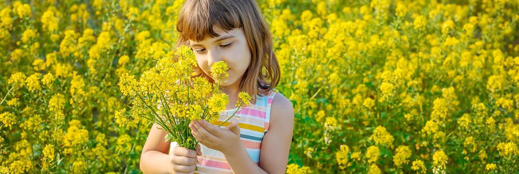 A child in a yellow field, mustard blooms. Selective focus..