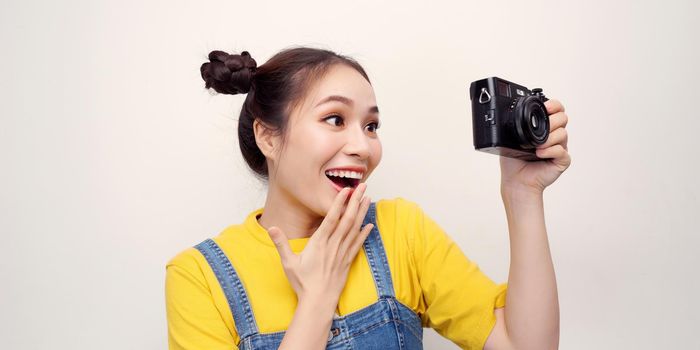 Smiling young woman using a camera to take photo.