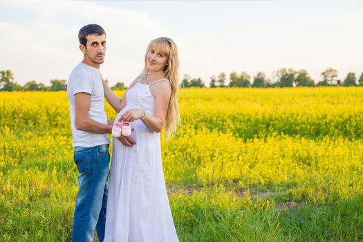 pregnant woman and man hold baby shoes. Selective focus. nature.