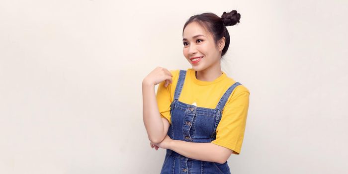 Joyful girl laughing in studio. Glad asian lady touching her face on white background.