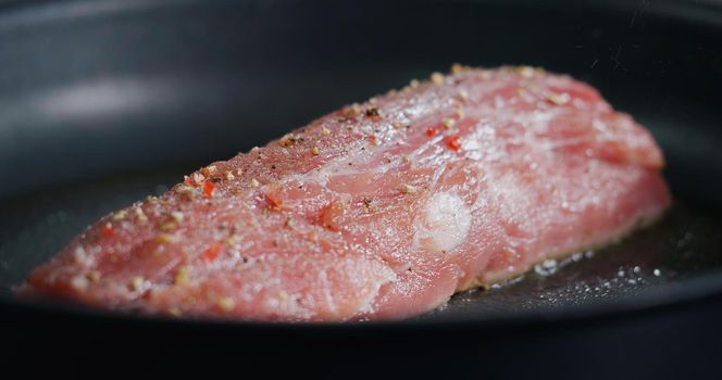 Close Up Raw Pork Meat Seasoned is Frying in Hot Pan.