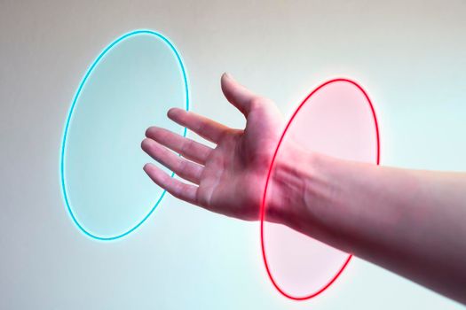 Hand entering in a neon light as a gate for new dimensions. Concept of new contemporary technology like metaverse, augmented reality and artificial intelligence.