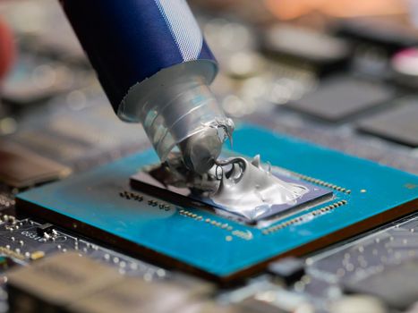 Thermal paste on the Laptop processor. Technician applying thermal paste to a GPU on laptop motherboard.