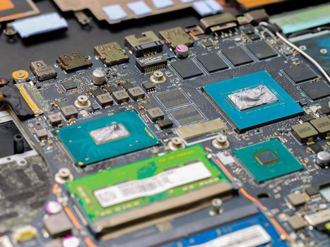 Graphics processor and CPU on the motherboard of a laptop computer, with thermal paste applied in the centre of the die. Cooling upgrade concept.