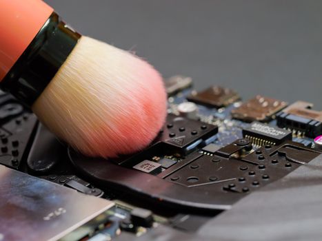 Macro of a brush cleaning a laptop fan. Cleaning a laptop at a professional service. PC care and repair concept, maintenance or prophylaxis.