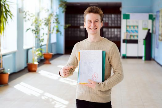 Student smiling at camera and pointing to the learning materials