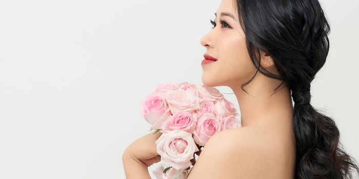 Portrait of a beautiful girl with a bouquet of roses. Beauty and fashion.
