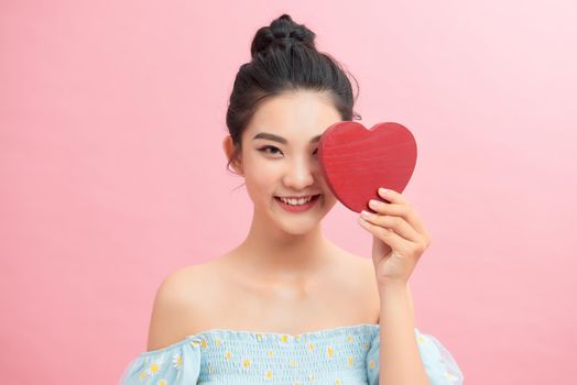 Woman holding paper heart shaped card . Valentine day concept .