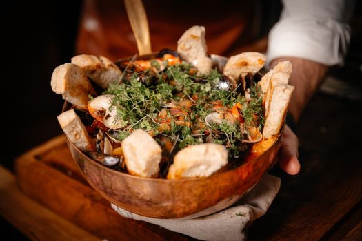 Exquisite decorated fish soup with sliced bread served in original bowl