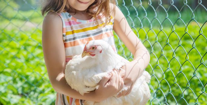 A child on a farm with a chicken. Selective focus.