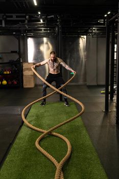 Rope man training gym warehouse fitness muscular exercising effort athlete, for strong fit from battle from practicing health, person wave. Field men outdoors,