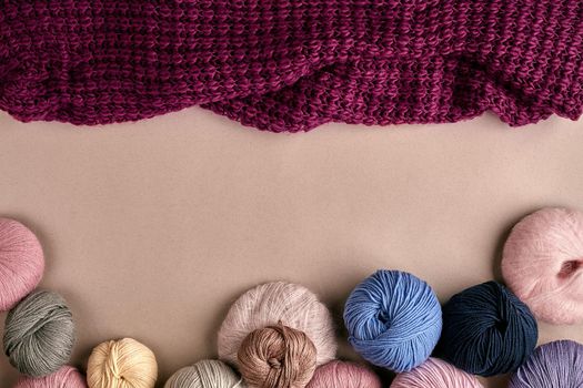 Set of colorful wool yarn on beige background. Knitting as a kind of needlework. Colorful balls of yarn and knitting needles. Top view. Still life. Copy space. Flat lay