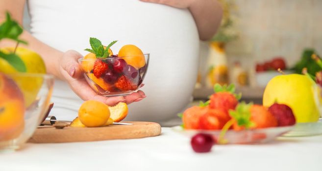 A pregnant woman eats fruit. Selective focus. food.