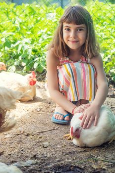 A child on a farm with a chicken. Selective focus.