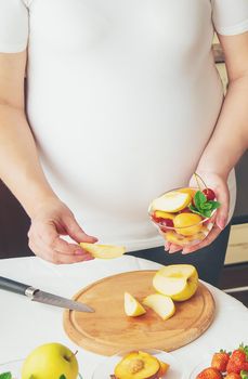 A pregnant woman eats fruit. Selective focus. food.